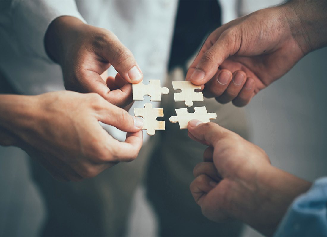 Additional Resources - Closeup View of the Hands of a Group of Businessmen Holding Small Wooden Puzzle Pieces in their Hands While Standing in the Office