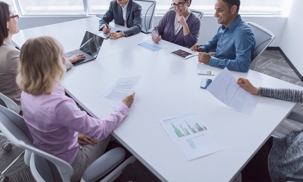 Blog - Workers Sitting Together at a Conference Table While Going Over Documents in the Office