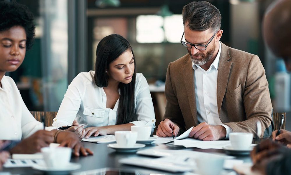 Time To Review Your Employee Handbook - Employees working together at a table