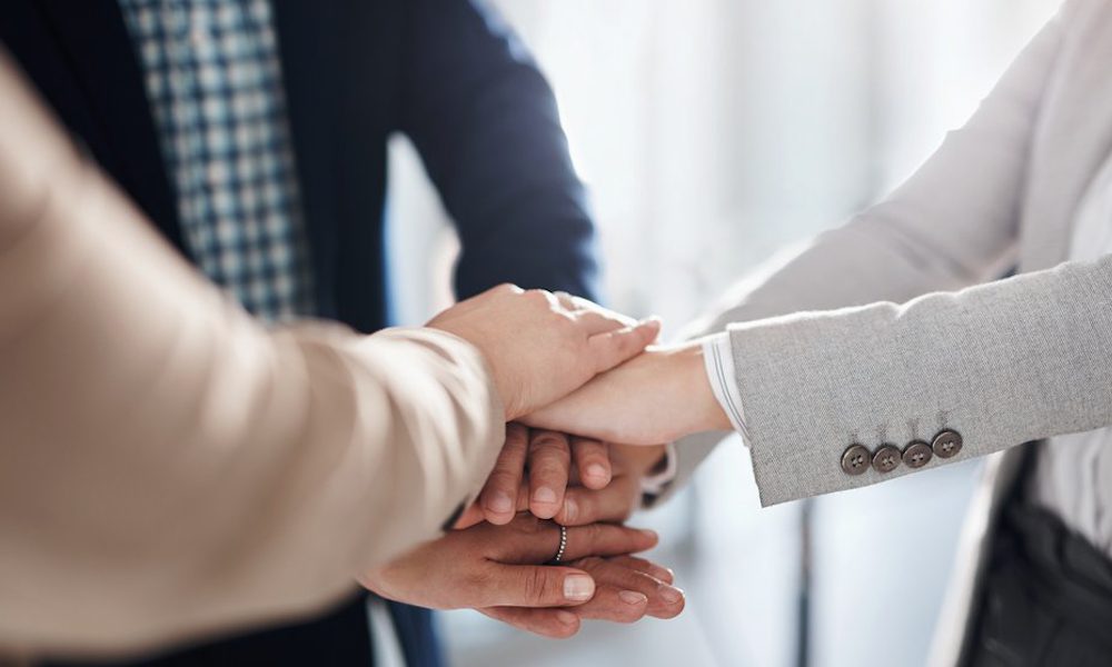 What Is a Captive Insurance Arrangement, and How Might It Benefit Your Business - Business Team Putting Their Hands Together