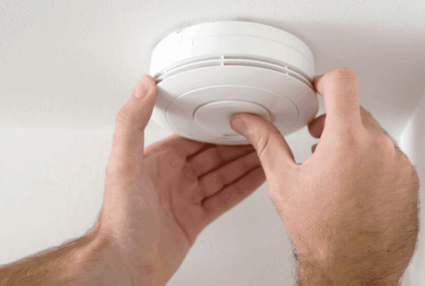 Test Your Fire Safety Knowledge - Person checking a smoke dector